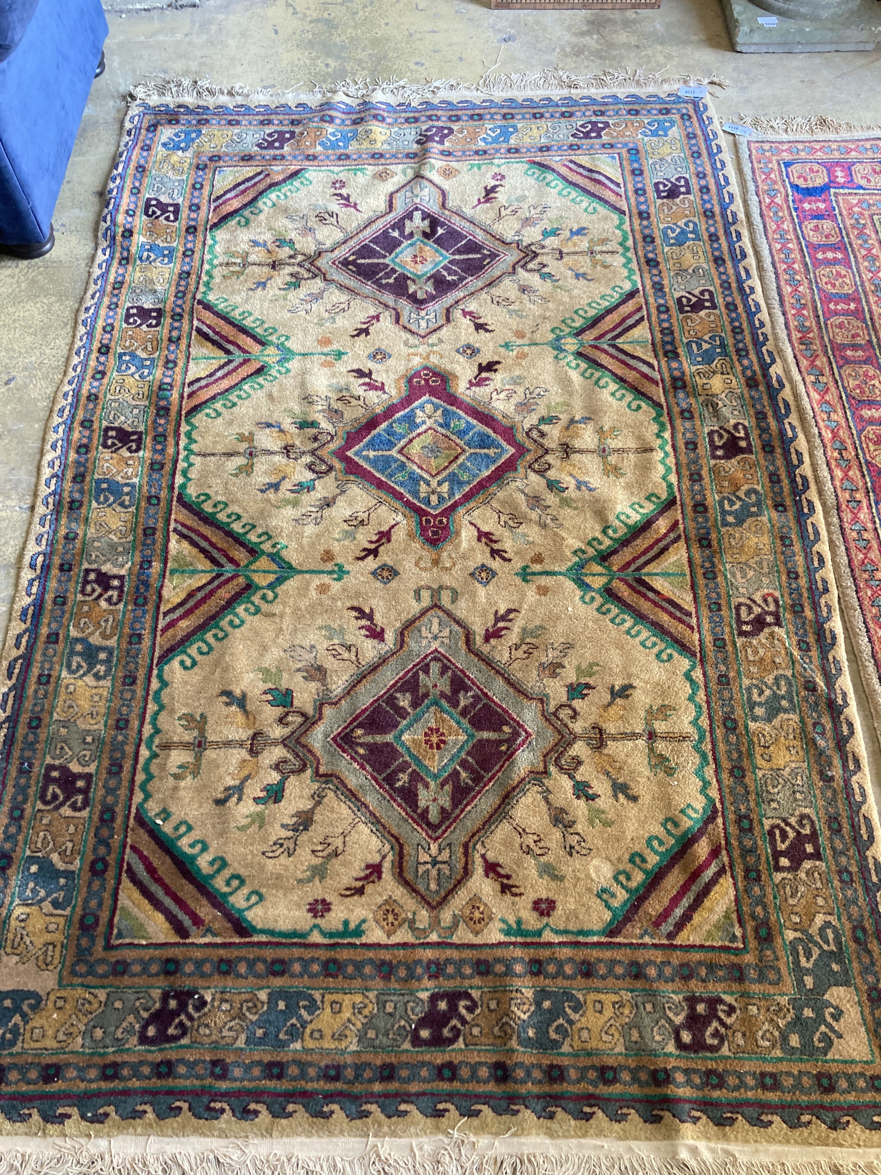 A Caucasian design fawn ground rug, 242 x 156cm